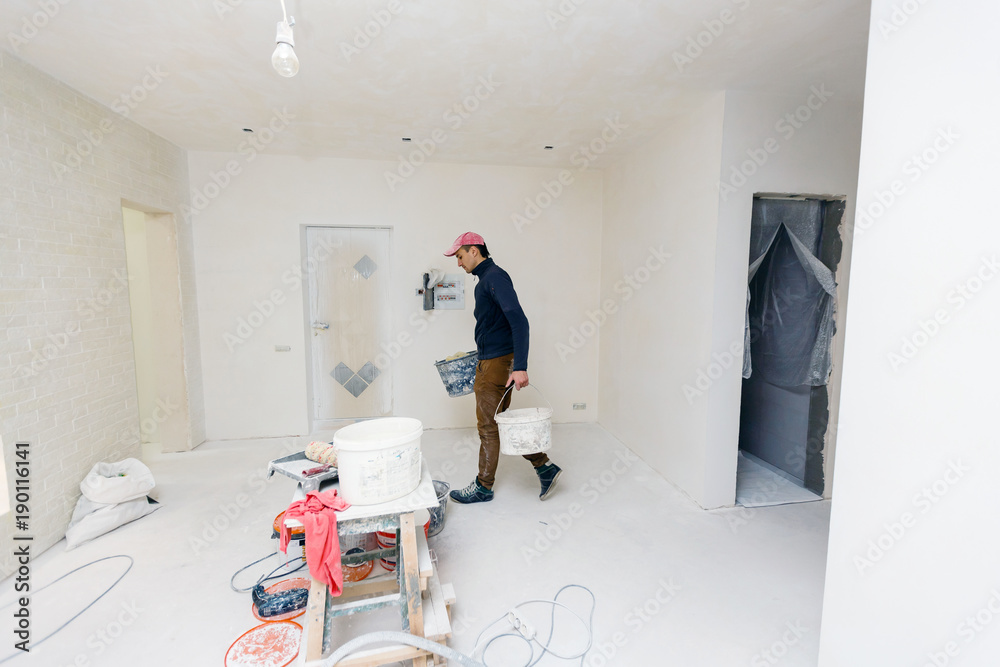 Young man does apartment repairment himself indoors