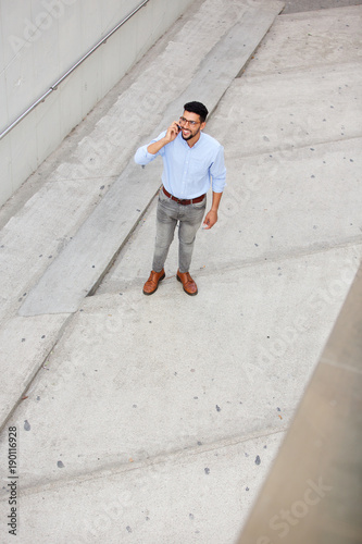 cool young arabic man smiling and talking on mobile phone © mimagephotos