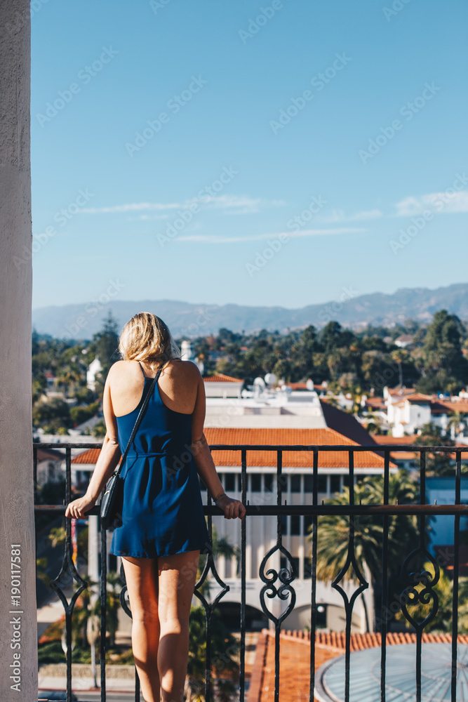 Blonde Woman in Blue Dress Looking Over City