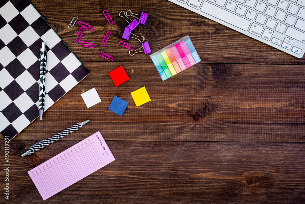 Fototapeta premium Student's desk. Keyboard. notebook, stationery on dark wooden background top view copy space