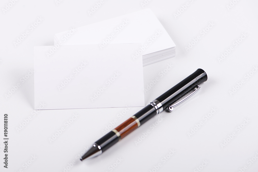 Business cards next to black pen on white background. Isolated. Mockup. Business cards next to black pen on white background. Isolated. Mockup.