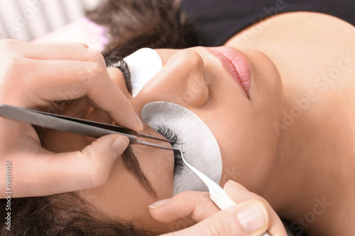 Photography Young woman undergoing eyelash extensions procedure, closeup