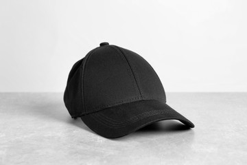 Black cap on table against white background. Mockup for design