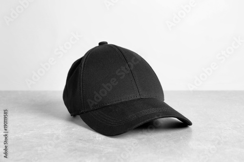 Black cap on table against white background. Mockup for design © Africa Studio