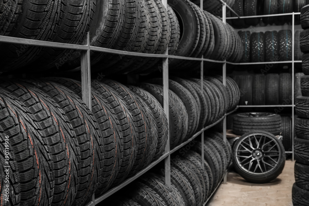 Rack with variety of car tires in automobile store Rack with variety of car tires in automobile store