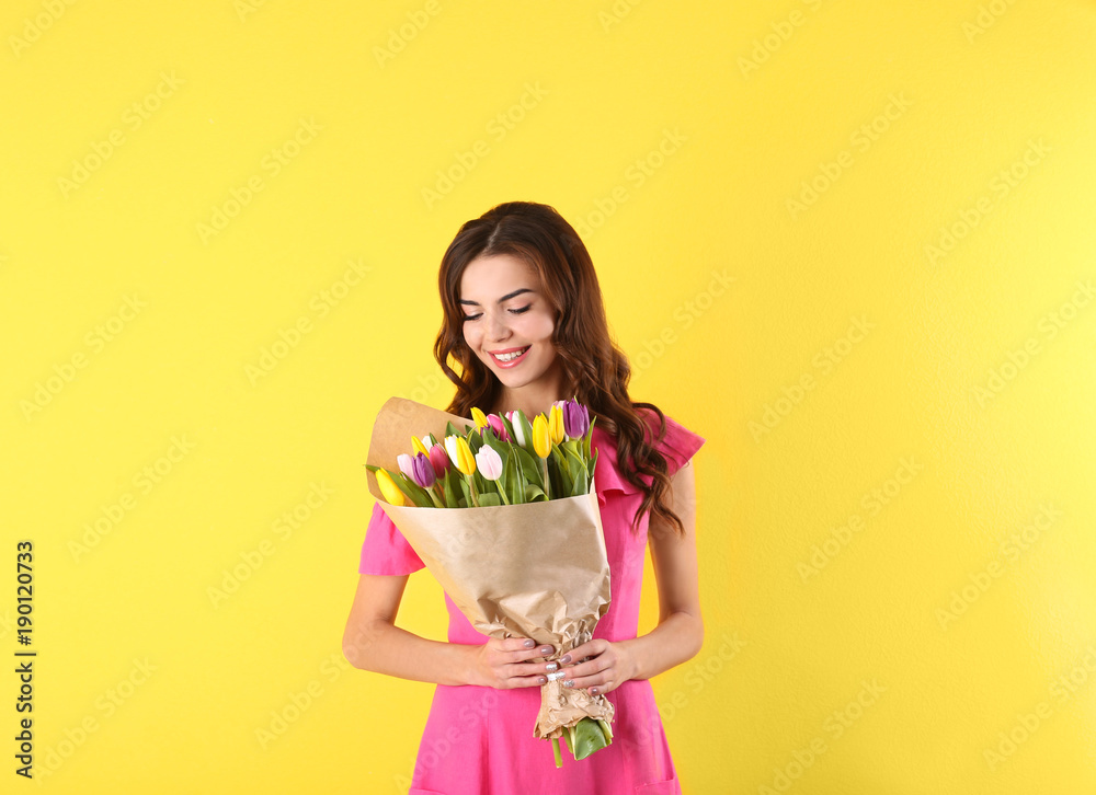 Beautiful woman holding bouquet of tulips on color background Beautiful woman holding bouquet of tulips on color background