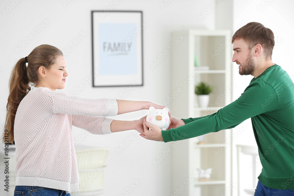 Couple with piggy bank at home. Money problems in relationship Couple with piggy bank at home. Money problems in relationship