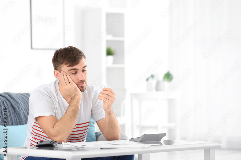 Sad man holding wedding ring at home. Problems in relationship Sad man holding wedding ring at home. Problems in relationship