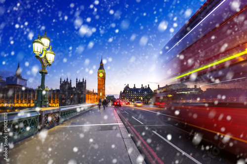 Big Ben and Westminster bridge on a cold winter night with falling snow, London, United Kingdom