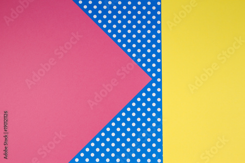 Abstract geometric yellow, pink and blue polka dot paper background.