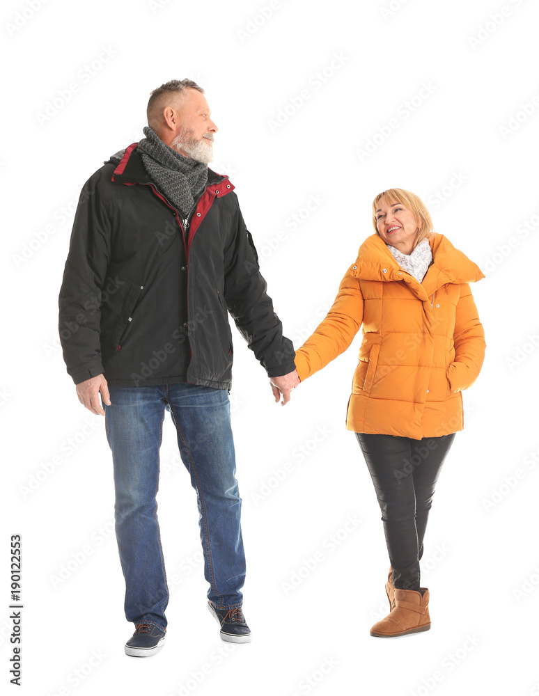 Mature couple in warm clothes walking on white background Mature couple in warm clothes walking on white background