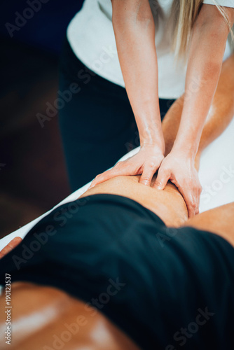 Sports massage. Physical therapyst massaging athlete's leg photo