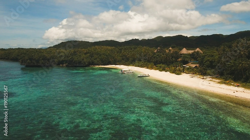 Aerial view of tropical beach on the island Bohol, Anda area, Philippines. Beautiful tropical island with sand beach, palm trees. Tropical landscape: beach with palm trees. Seascape: Ocean, sky, sea