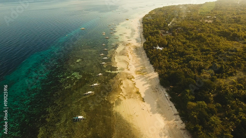 Aerial view of tropica Alona beach on the island Bohol, resort, hotels, Philippines. Beautiful tropical island with sand beach, palm trees. Tropical landscape. Seascape: Ocean, sky, sea. Travel