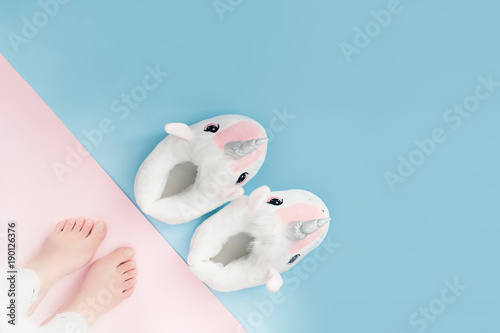 pop art pair of fluffy white unicorn slippers on pastel colour background