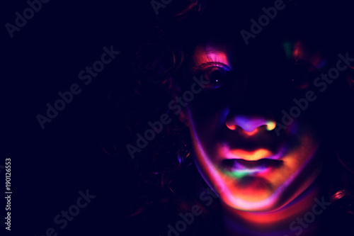 abstract portrait of young girl under colorful fluorescent Neon dark lights  enigmatic style.