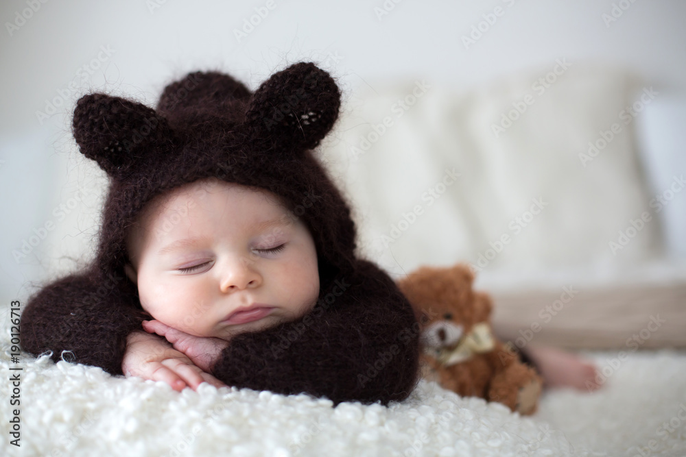 Sweet little baby boy, dressed in handmade knitted brown soft teddy bear  overall, sleeping cozy Stock Photo | Adobe Stock