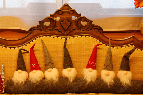 Group of Christmas soft toy elves A small cute Xmas gnomes sits on a couch. Front view of a small gnome. Christmas symbol. Beautiful, cute Interior Decoration. photo