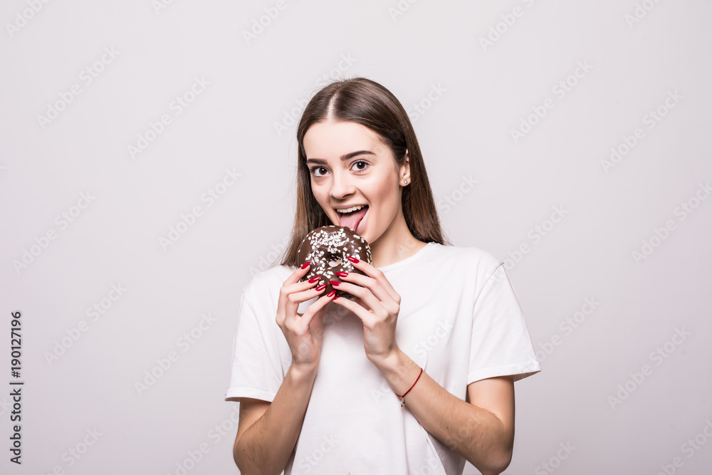 Close up portrait of a satisfied pretty girl eating donuts isolated over white background. Health concept Close up portrait of a satisfied pretty girl eating donuts isolated over white background. Health concept