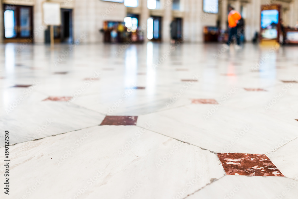 Closeup of red, orange tiled marble floor squares with bokeh in Union Station entrance in Washington DC