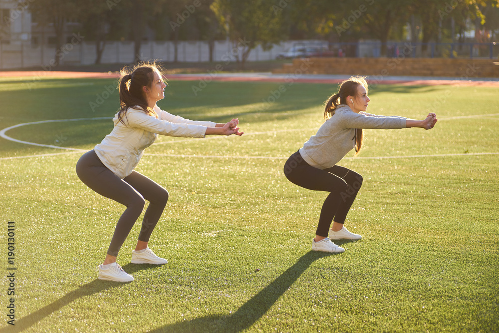 Ταπετσαρία two young sports girls doing gymnastics in the morning on the green grass