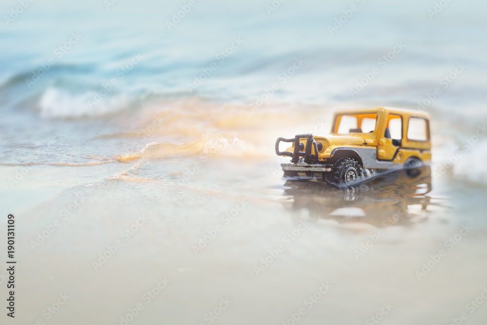 Car  (miniature, toy model ) crossing the sea with splashing water, Travel and racing concept.