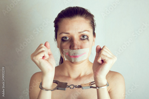 Unhappy woman with wrapping her mouth by adhesive tape painted smile photo