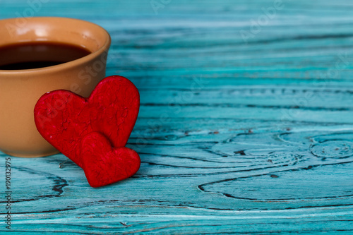 On a wooden background are the hearts with a cup of coffee. Valentine's day concept. photo