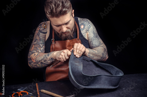 Craftsman working with leather keen on one's business