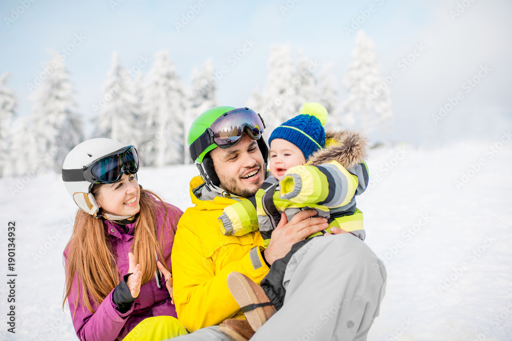 Portrait of a happy family with baby boy during the winter vacations on the beautiful snow-covered mountains Portrait of a happy family with baby boy during the winter vacations on the beautiful snow-covered mountains