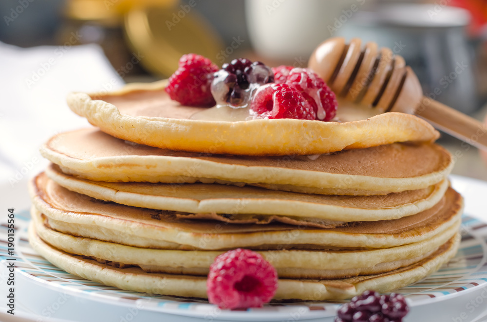 Photo of delicious pancakes with berries and honey over wooden tabe Photo of delicious pancakes with berries and honey over wooden tabe