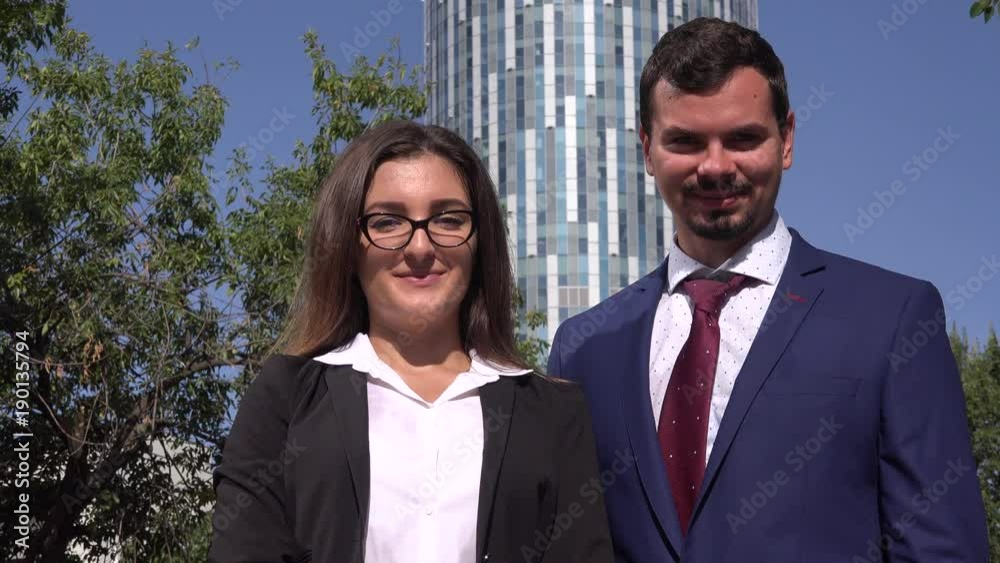 Business skyscraper background standing professional smiling team group outdoors Business skyscraper background standing professional smiling team group outdoors