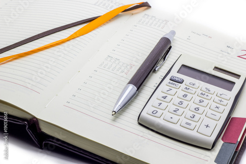 Diary with calculator and pen on white background, business manager set.