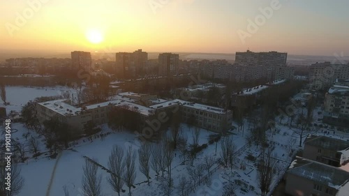 An unusual bird`s eye view of the snowy roofs of multistoreyed buildings and their courts in a Ukrainian city at a wonderful sunset in winter photo