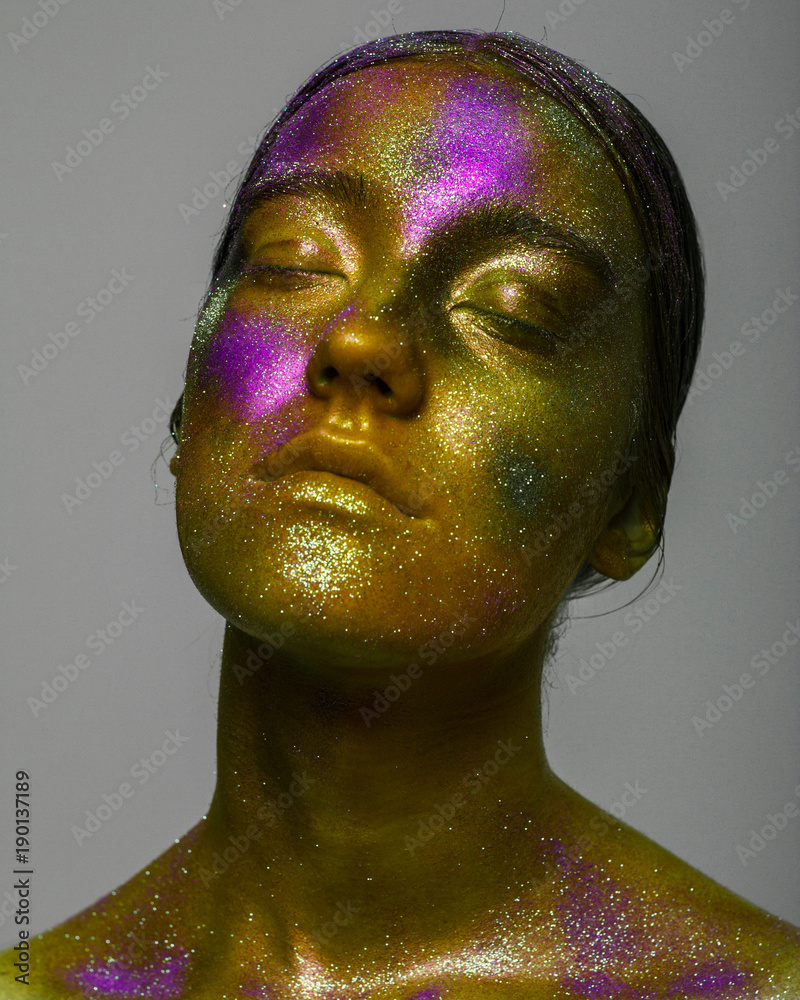 Glowing neon makeup with dramatic look in his eyes. Creative body art on  the theme of space and stars. Amazing close-up portrait glow in the dark  makeup. Stock Photo