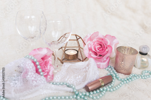 Valentines Day concept. White bra with wine glasses, roses and candles on white textured background. Isolated.