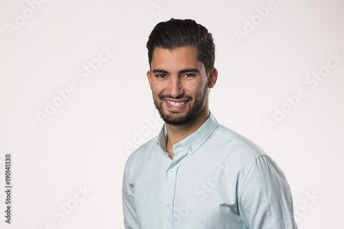 Portrait of attractive man with trendy hairdo and beard, being in good mood, expresses positive emotions © Walid