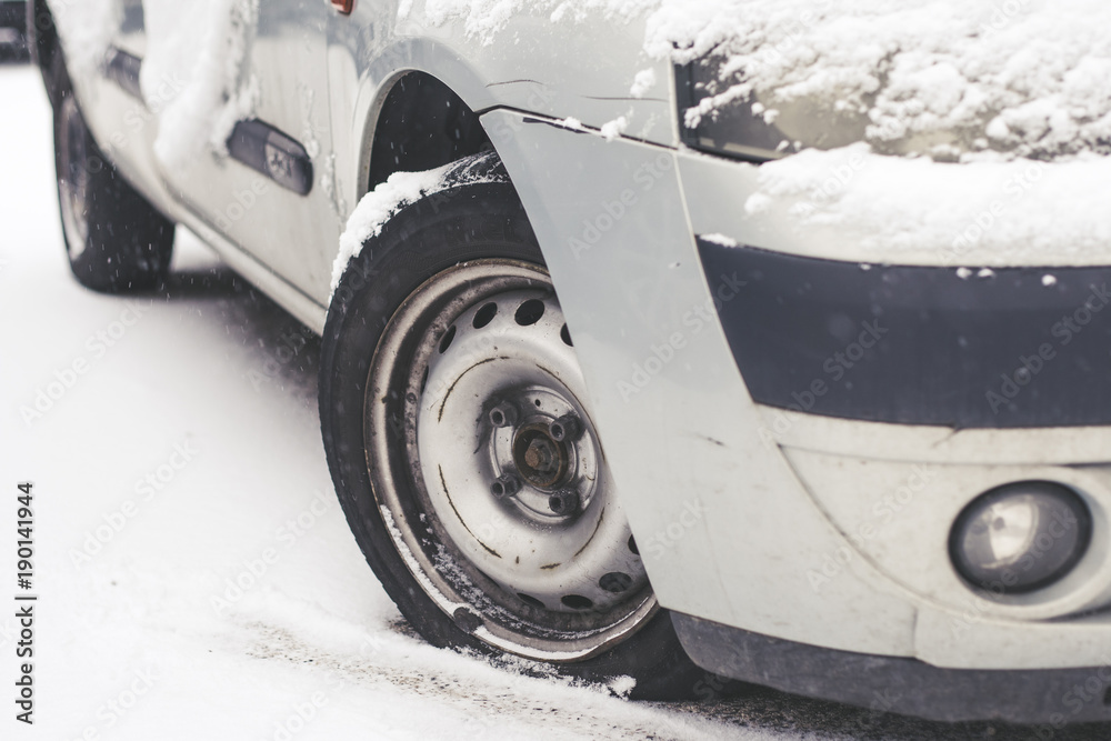 Close up wheel flat tire of the car in snow in winter