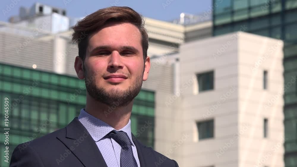Close-up portrait handsome positive young business man in the city smiling happy