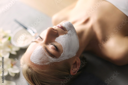 Face mask.Beautiful young girl at spa ,cosmetician woman applying facial mask