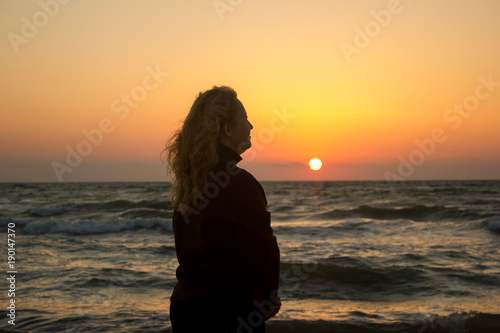 Silhouette of a girl on the beach at sunrise