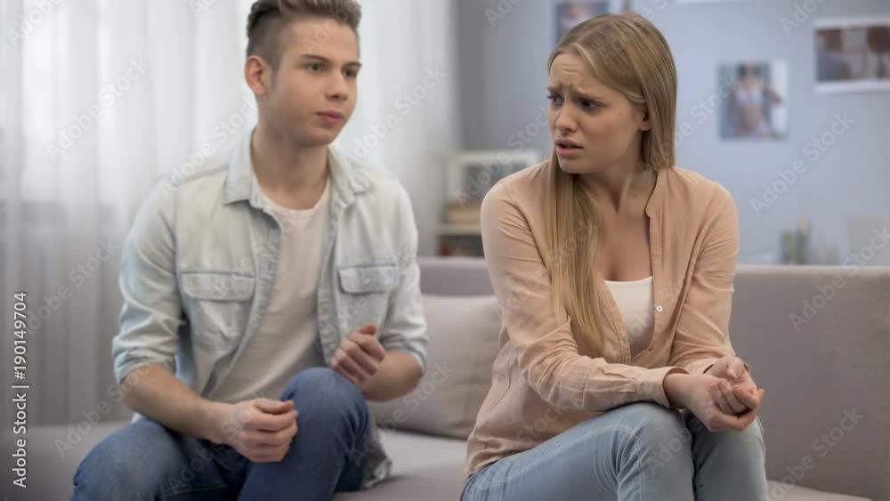 Couple of teenagers quarrelling and screaming at home, emotional girl crying Couple of teenagers quarrelling and screaming at home, emotional girl crying
