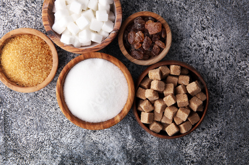 Various types of sugar, brown sugar and white on grey table