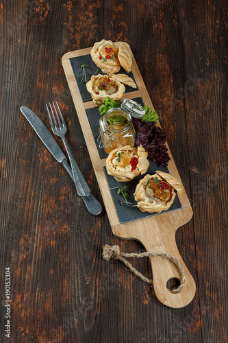 Tartlets with liver pate from duck or chicken livers and a sauce of sea-buckthorn are on the Board. photo