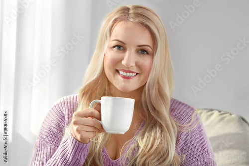 Mature smiling woman drinki...