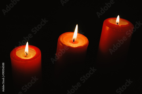 Beautiful candles burning on a black backgrounds