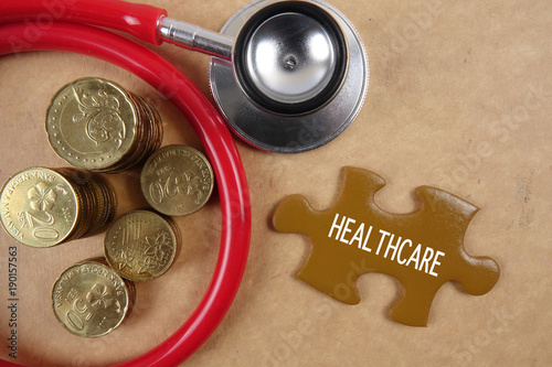 Medical concept with stethoscope,piece of puzzle and coins . photo