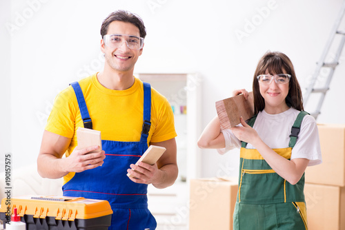 Man explaining woman woodworking tips in wood workshop