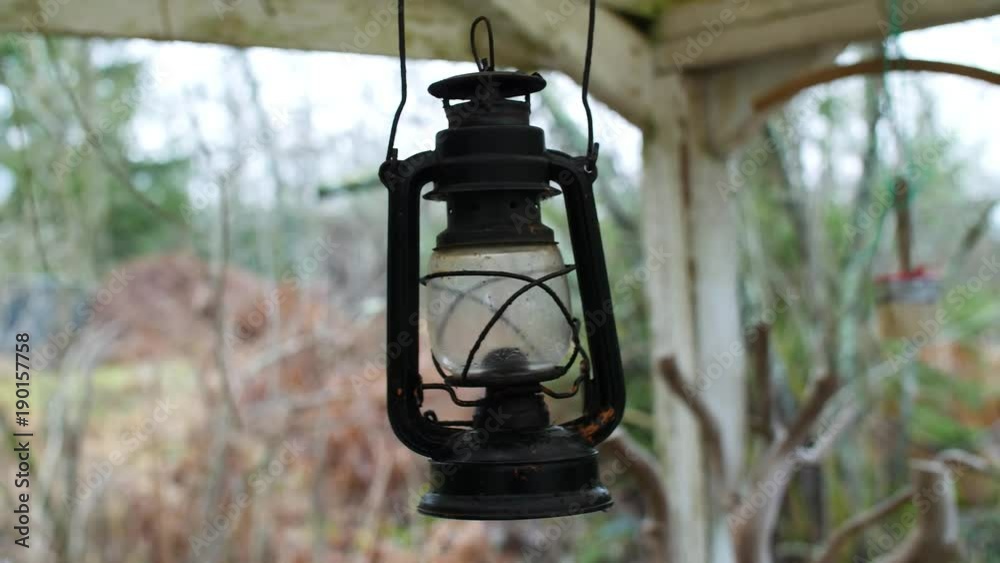 Vintage camping/oil lamp swinging back and forth in the wind