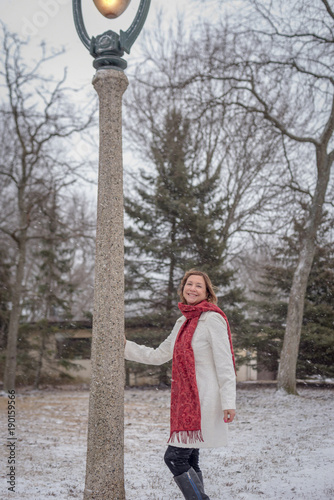 woman standing next to ornate lamp post posing for photo on snowy winter day in Milwaukee, Wisconsin photo